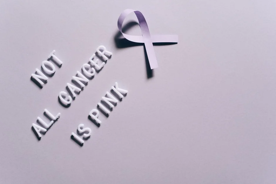 Cancer Myths & Facts Debunked – Shreenath Cancer Care Junagadh Cancer awareness poster with a purple ribbon on a gray background.